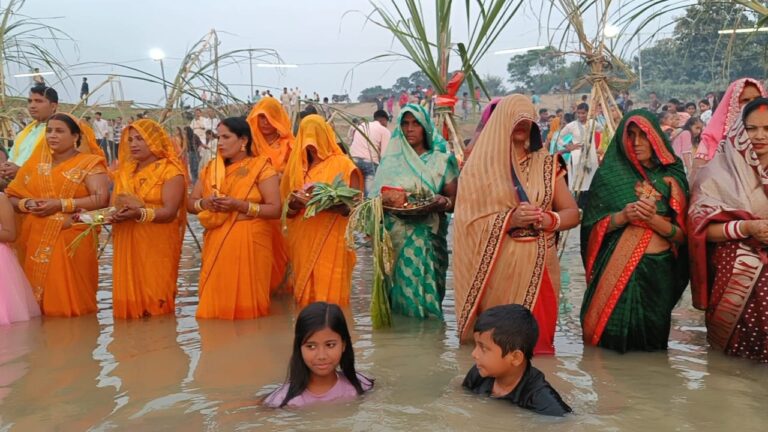 गोरखपुर में डूबते सूर्य को अर्ध्य देने के लिए जल में खड़ी वर्ती महिलाएं।